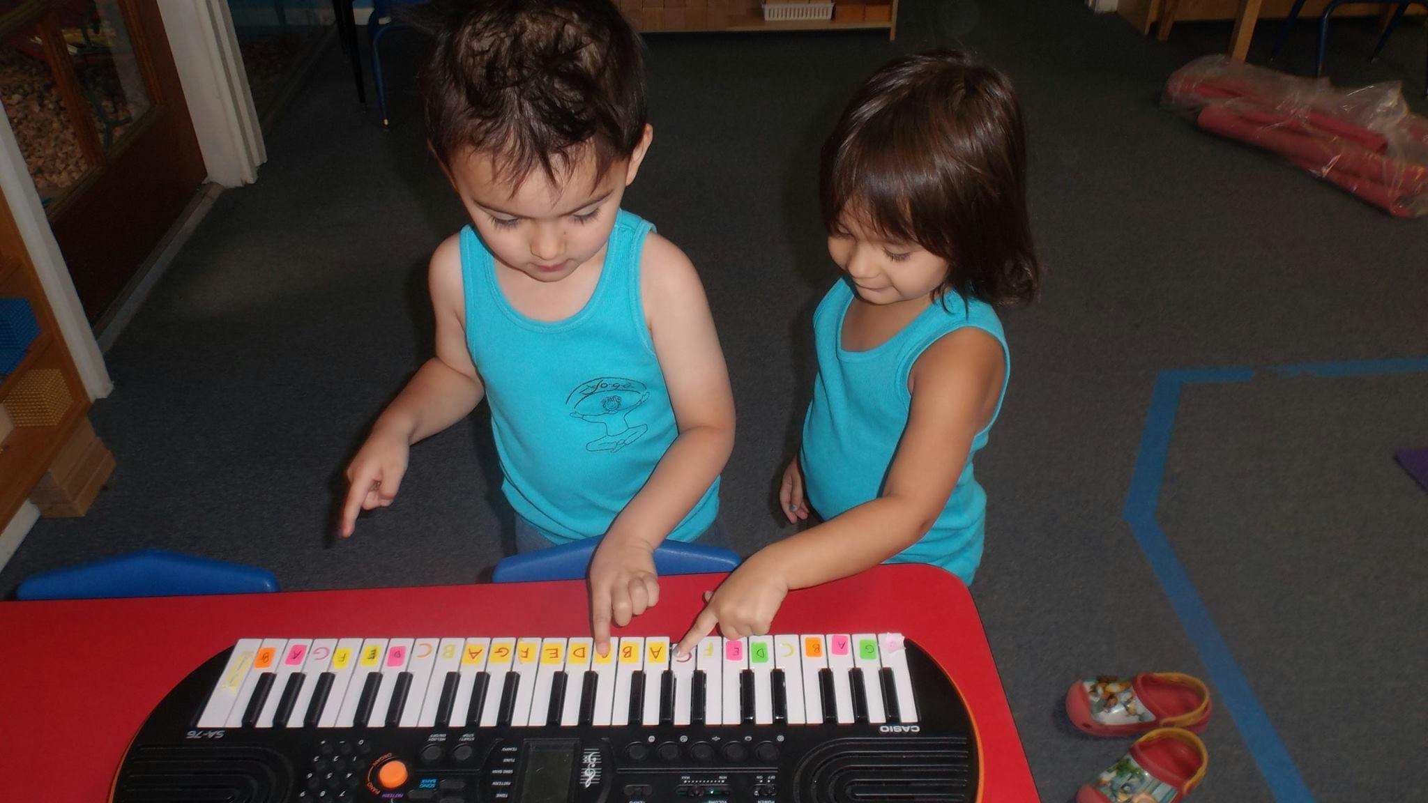 Two children playing a keyboard