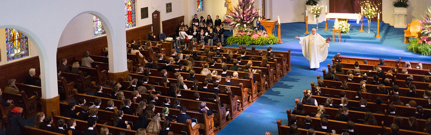 People in pews watching a speaker in a church