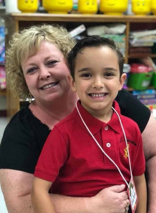 Adult and child smiling in a classroom