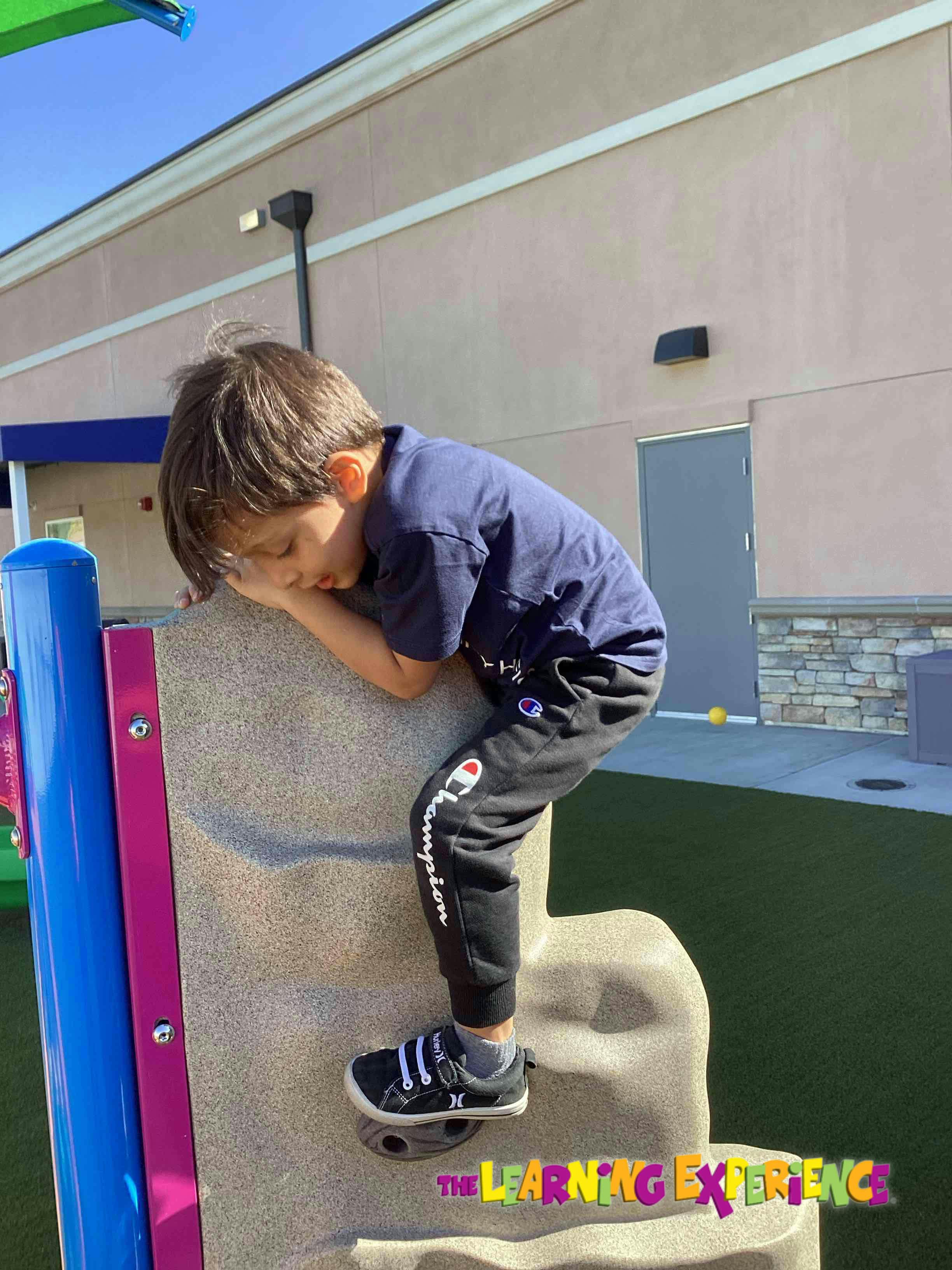 Child climbing a rock wall on a playground