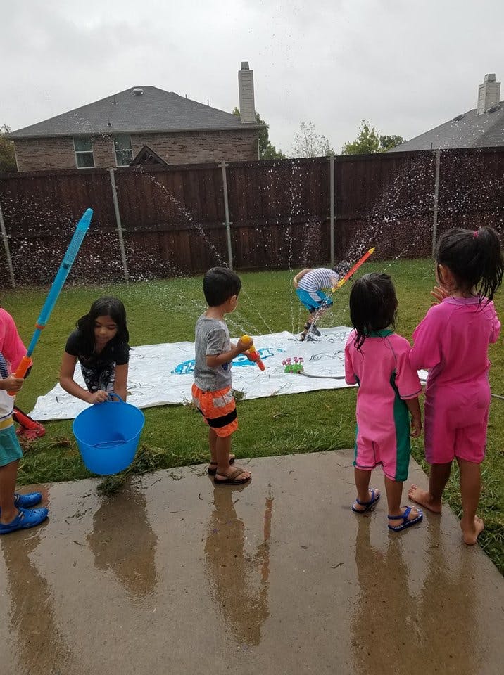Children playing with water in a backyard