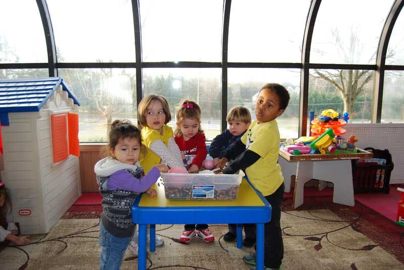 Children gathered around a table with a container