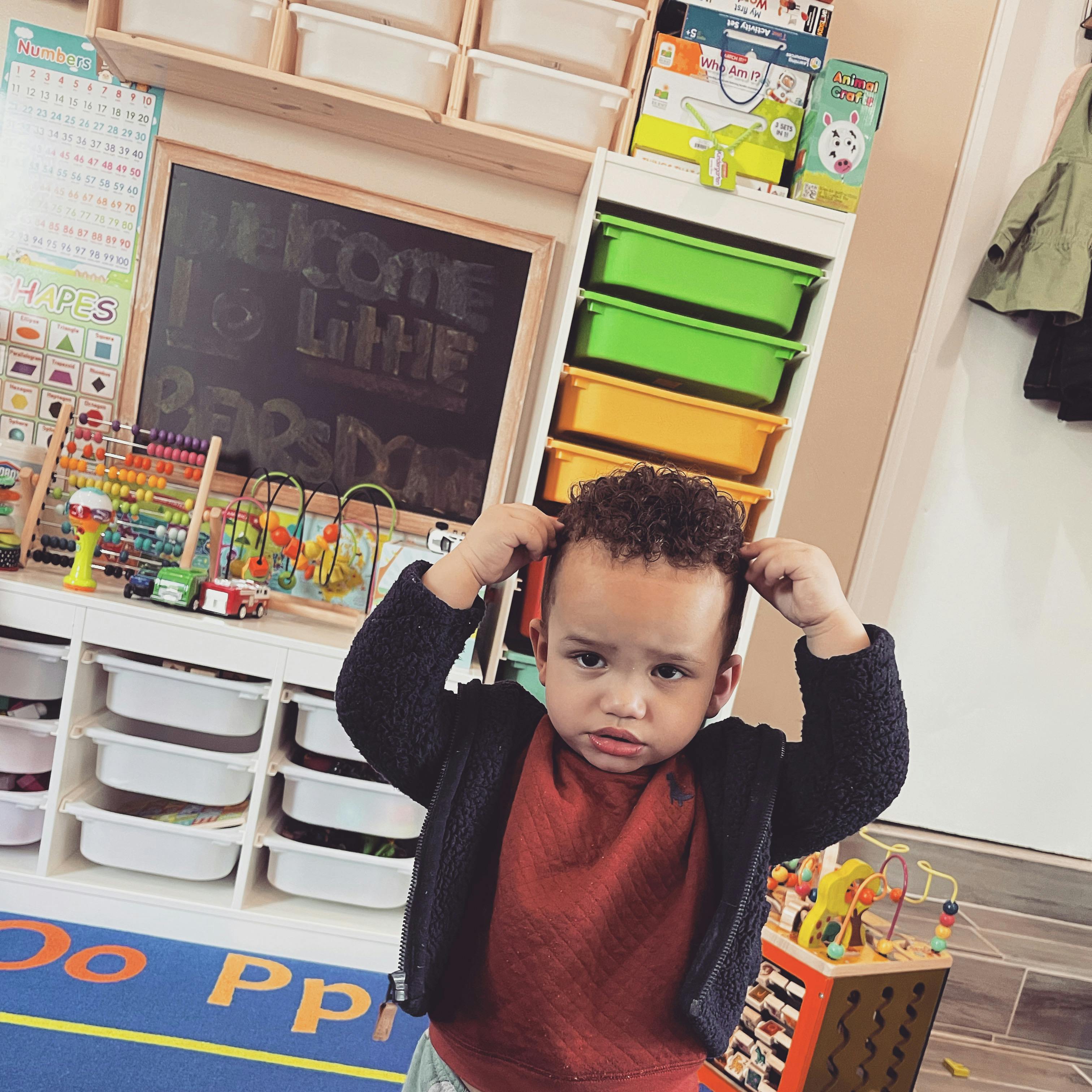 Child with hands on head in a classroom