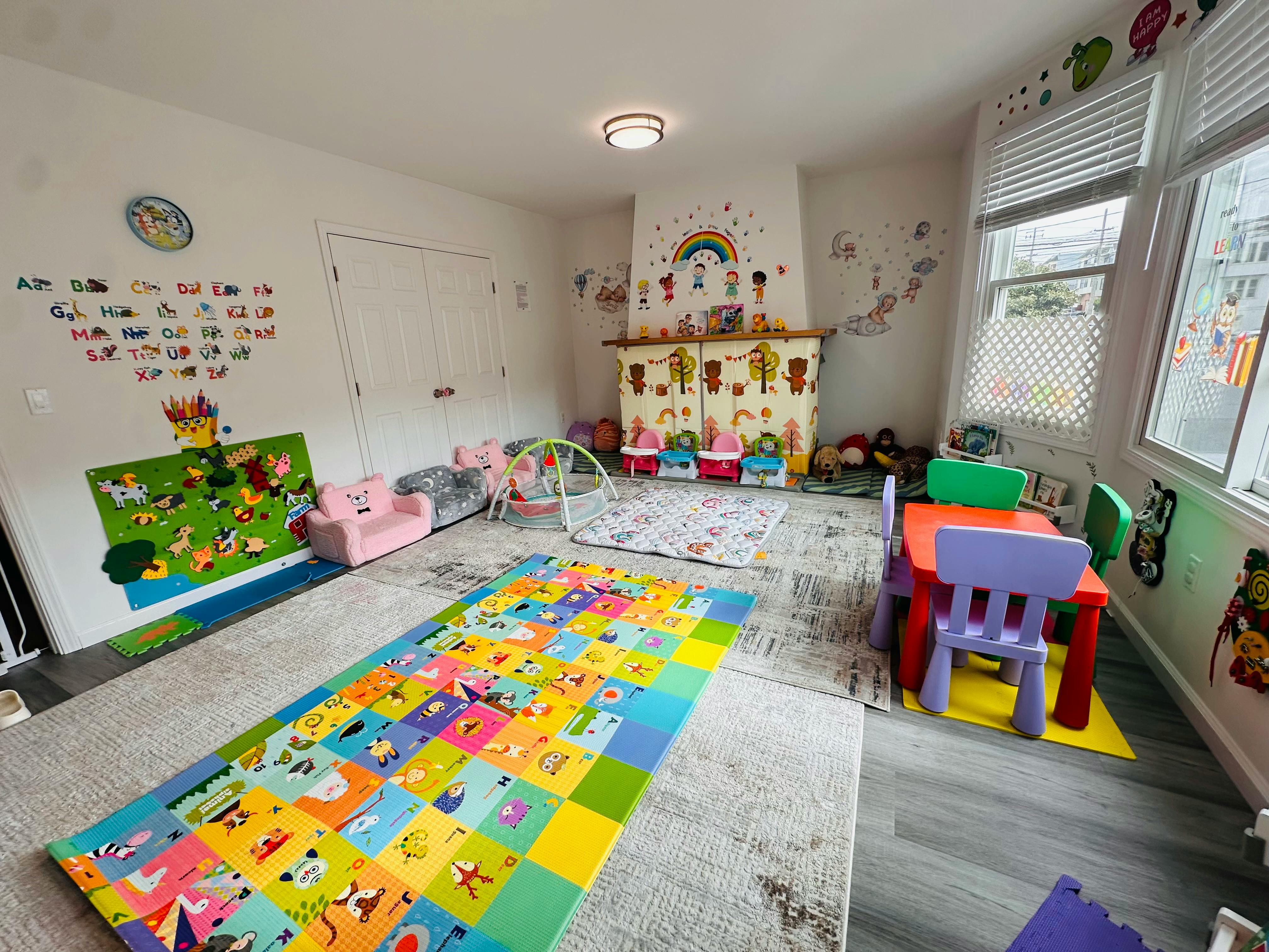 Playroom with colorful mats, small table and chairs, and toys