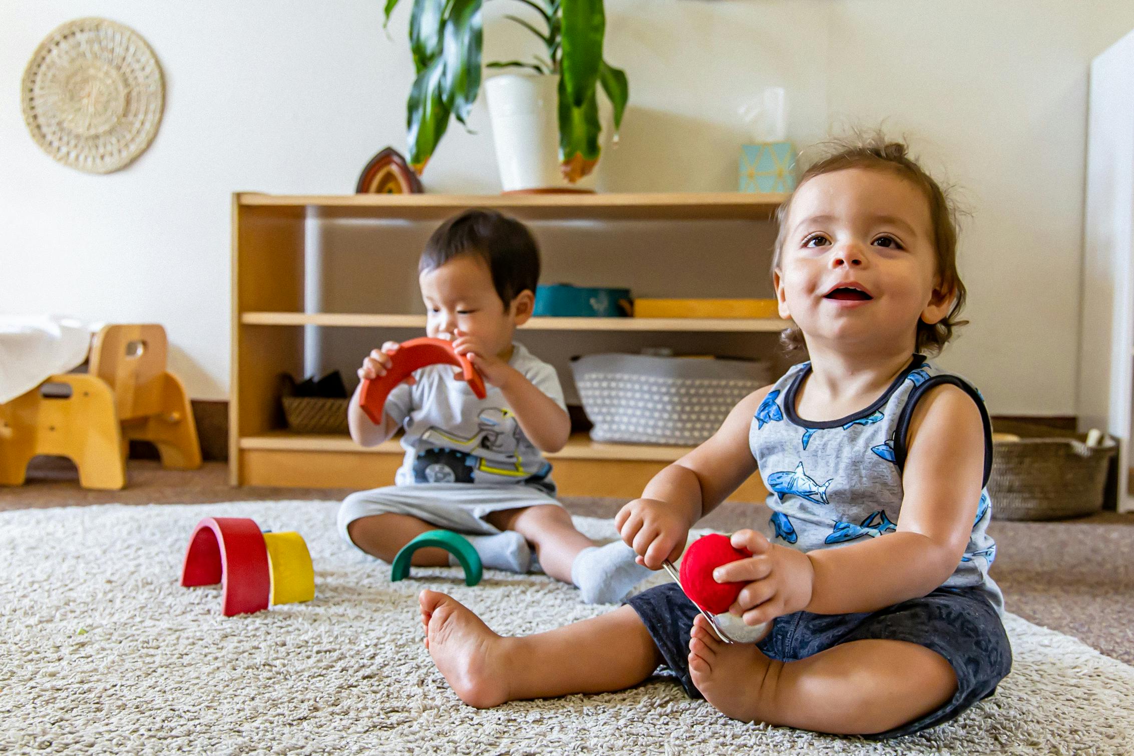Two children playing with toys on a rug