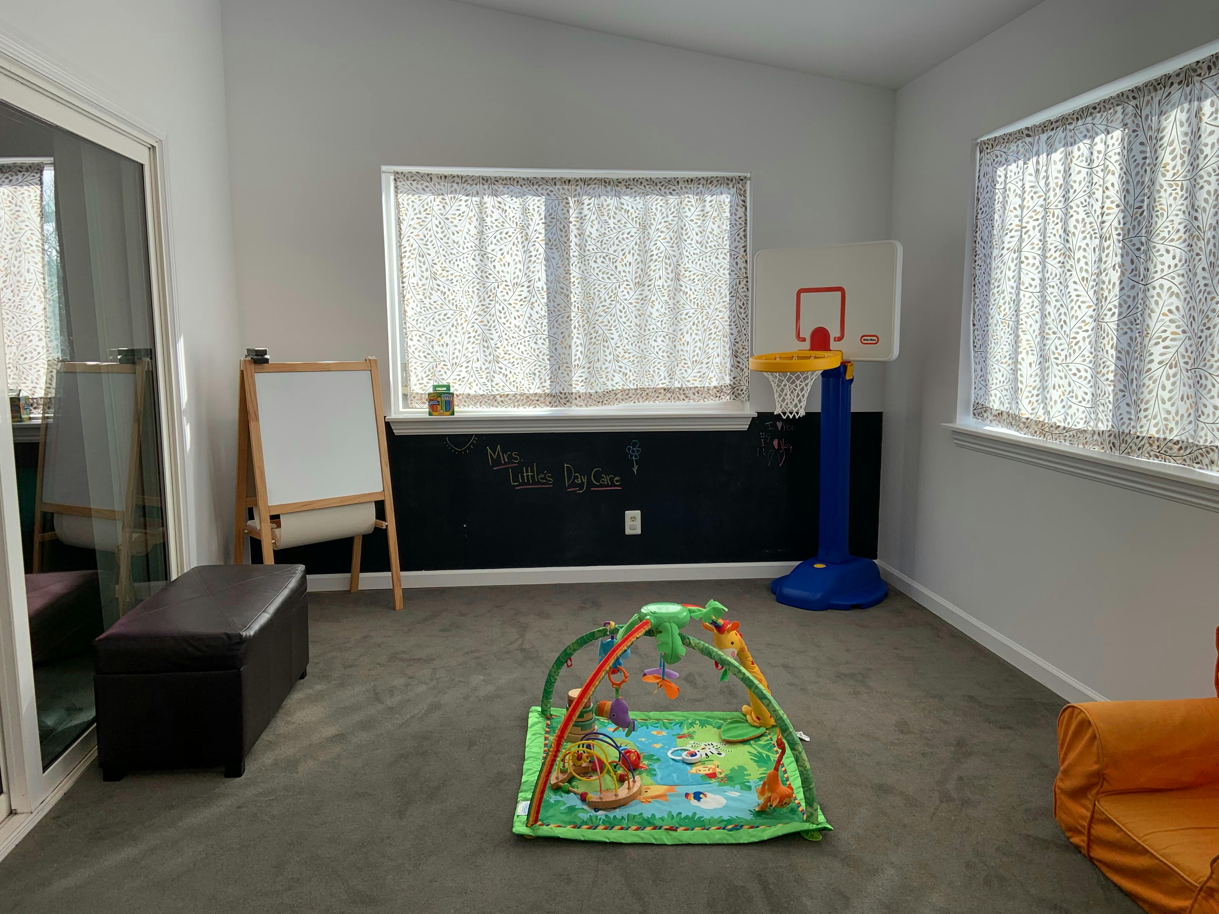 Playroom with a baby play mat, easel, and toy basketball hoop