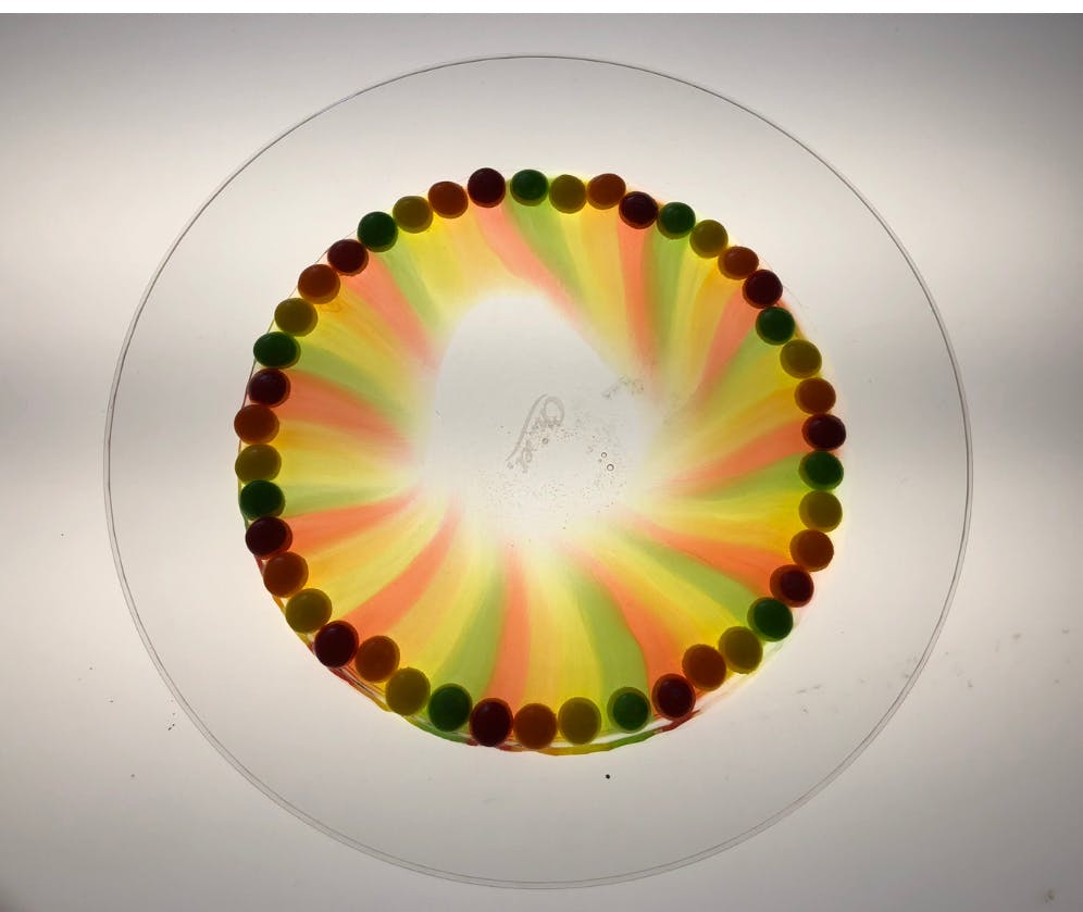 Circular arrangement of colorful candies with radiating color streaks