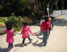 Children walking in a line holding a rope