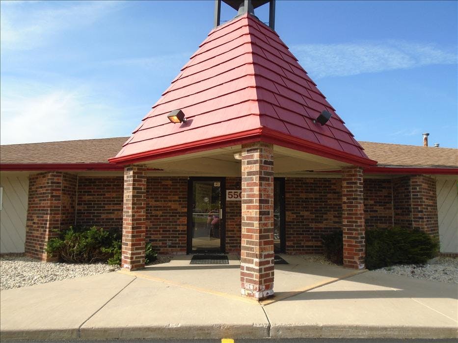 Entrance to a brick building with a red peaked roof over the doorway