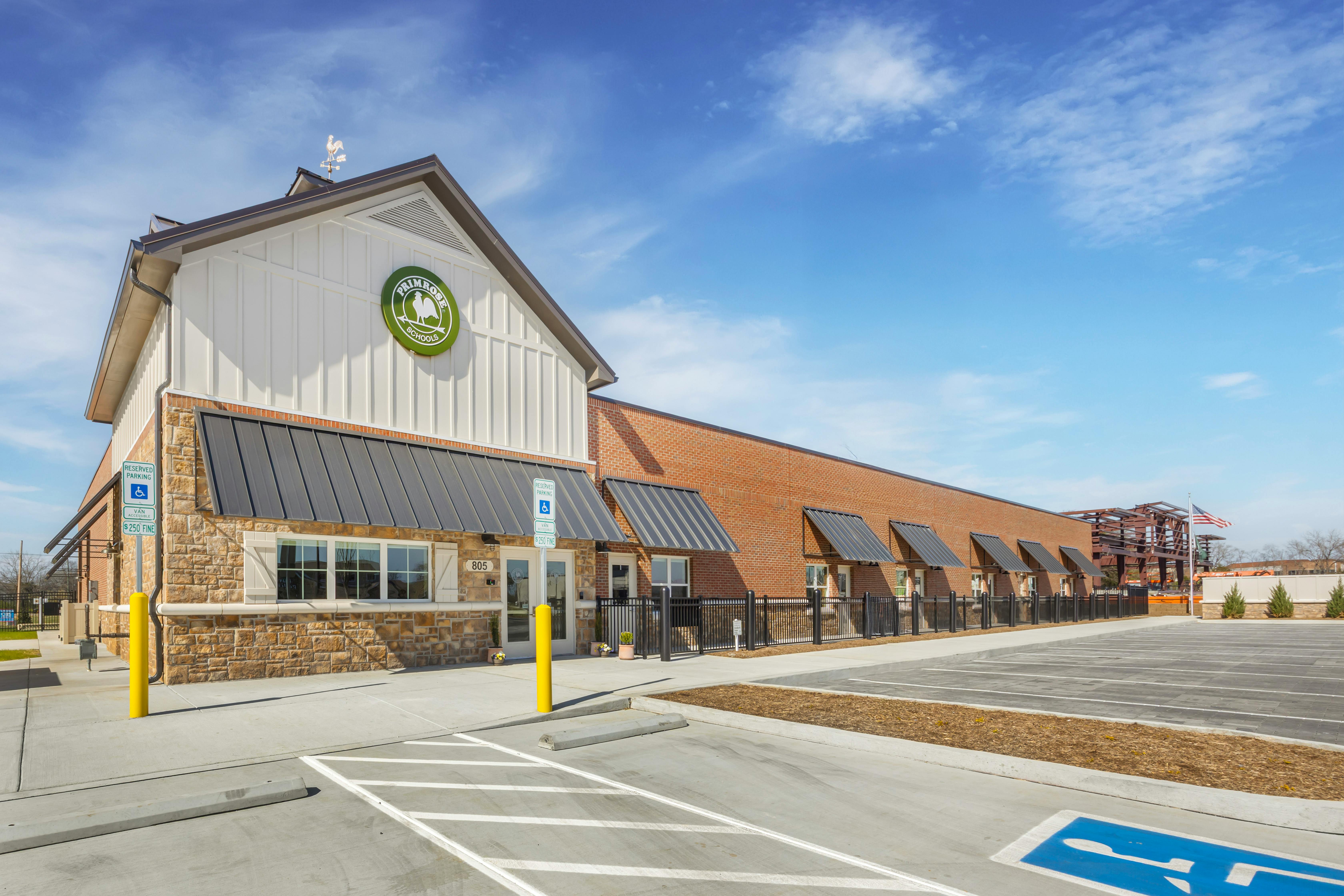 Primrose Schools building exterior with brick and white siding, parking lot