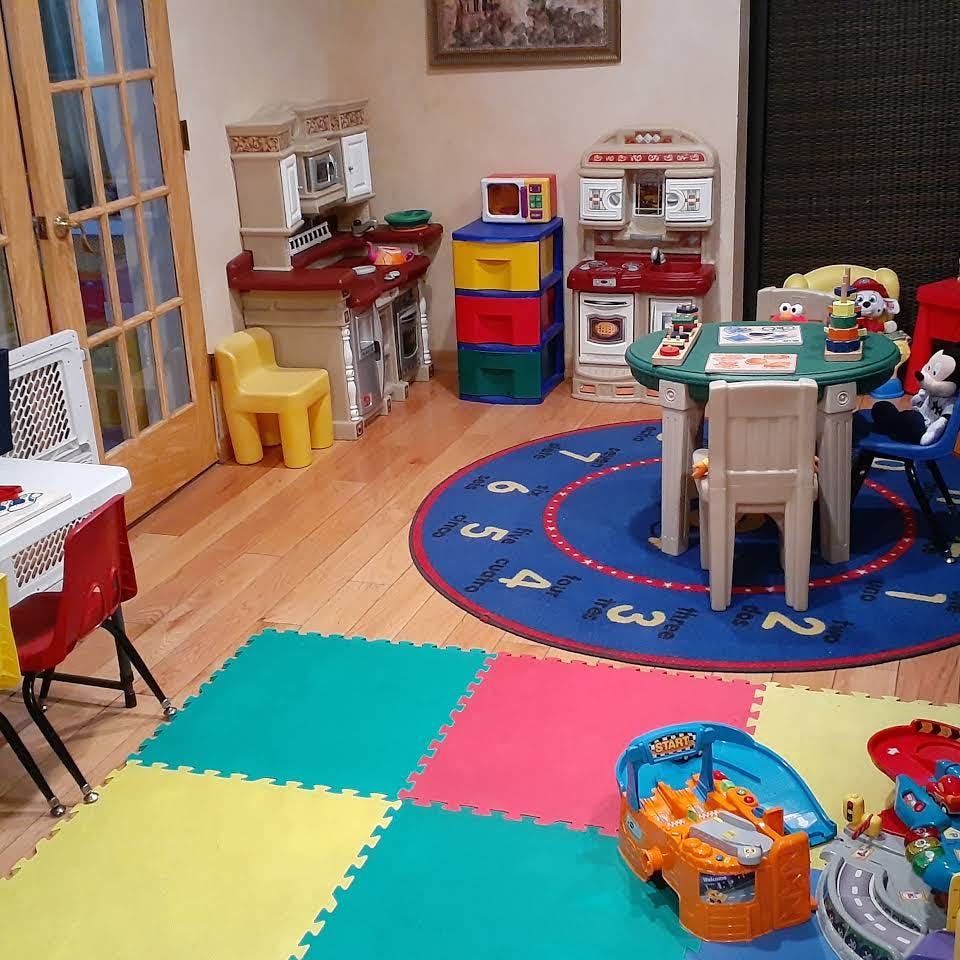 Playroom with toy kitchen, table and chairs, and colorful floor mats