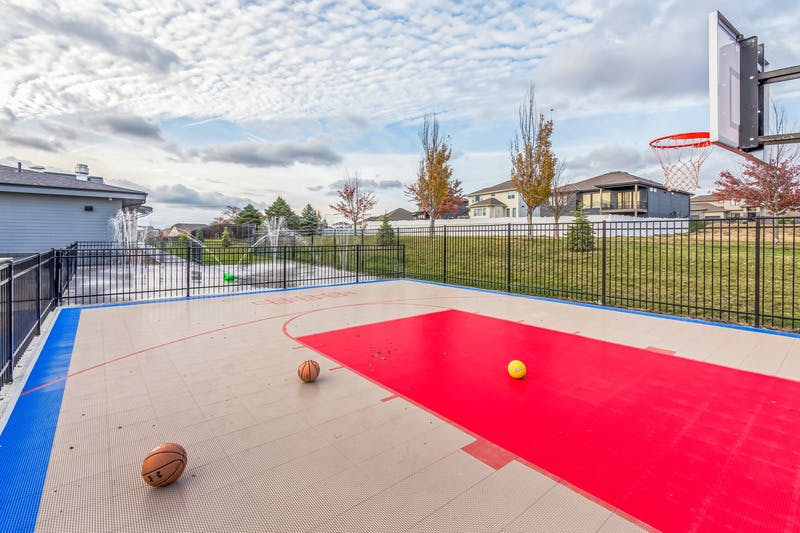 Basketball court with two basketballs and a yellow ball, basketball hoop