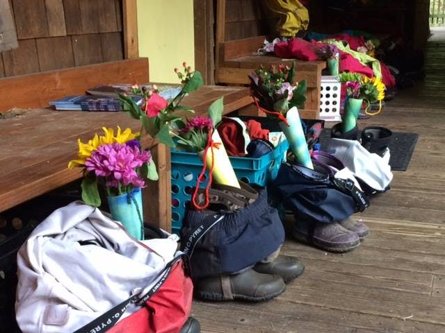 Bags and boots with flowers on a wooden floor