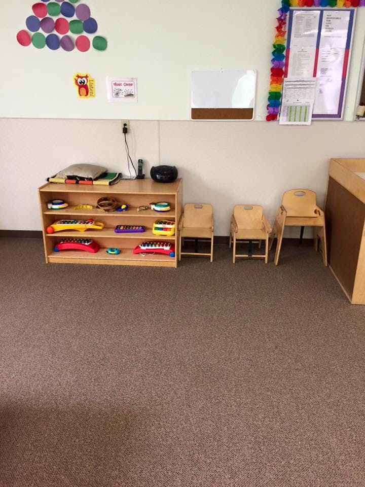 Classroom with a wooden shelf of toys and small chairs