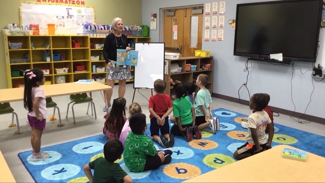 Adult reading to children in a classroom