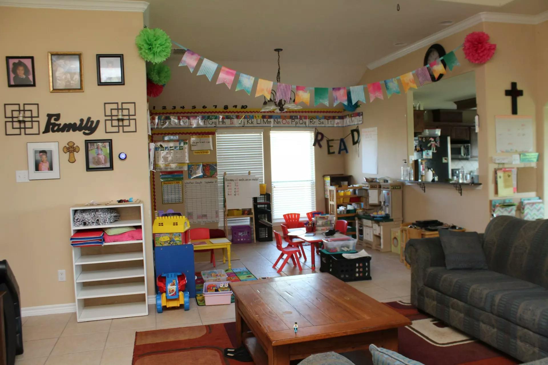 Living room decorated with colorful banner and children's play area