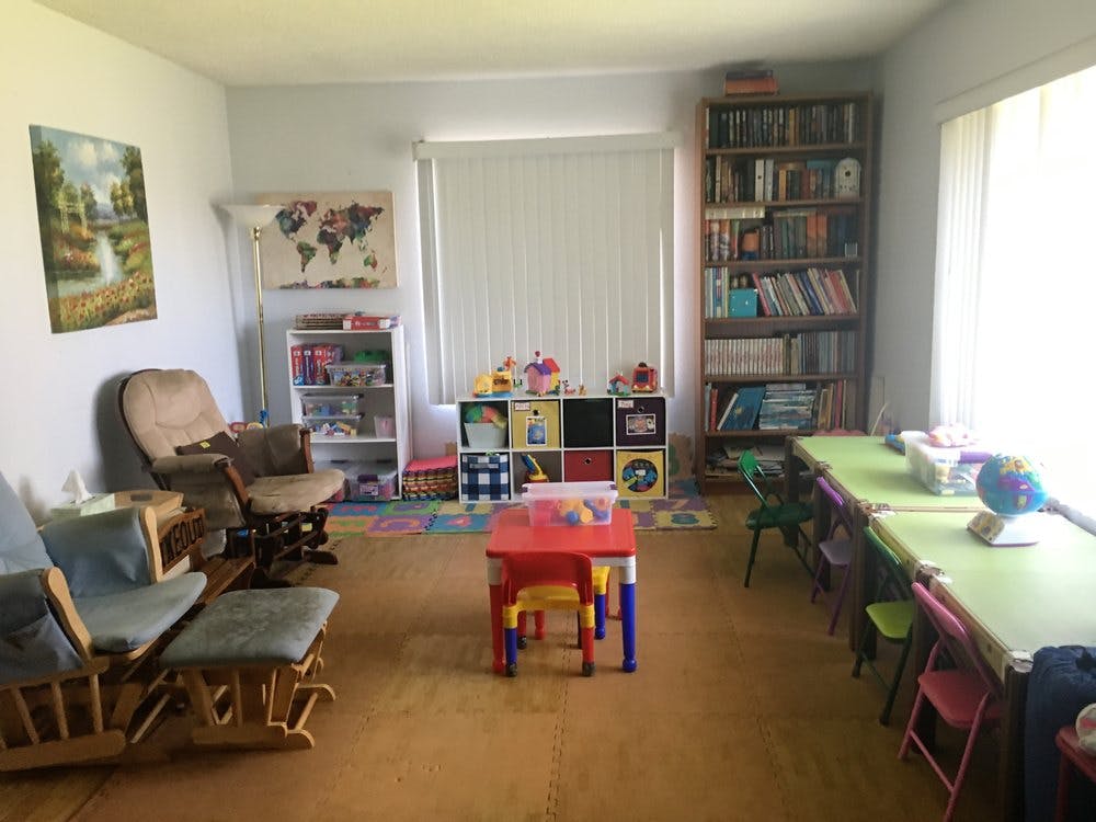 Room with children's tables and chairs, bookshelves, and rocking chairs