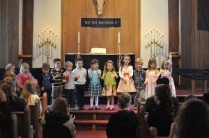 Children standing on a stage in a church
