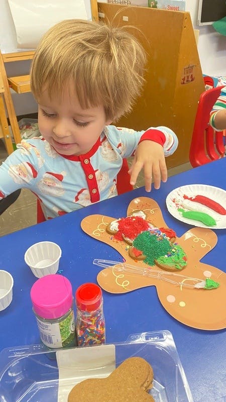 Child decorating a gingerbread cookie