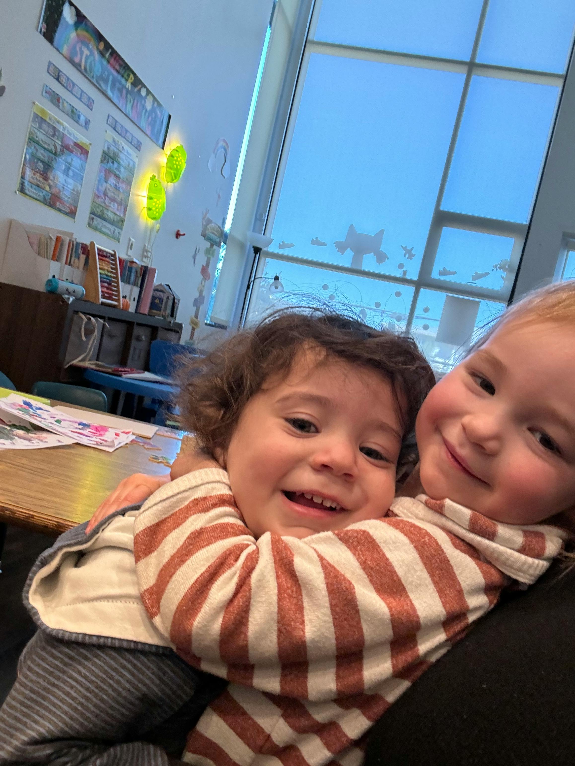 Two children embracing in a classroom