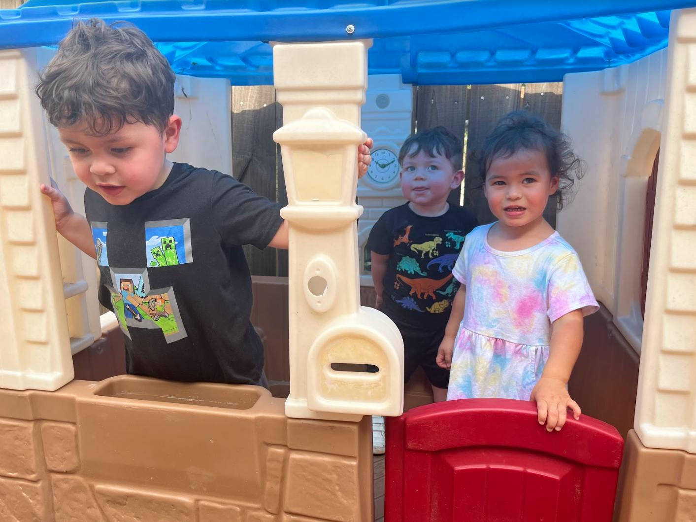Three children playing in a playhouse