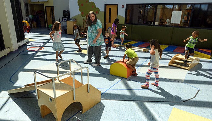 Adult and children playing in an indoor area with soft play equipment