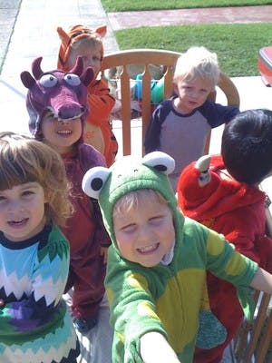 Children in costumes, including a frog, dragon, and tiger
