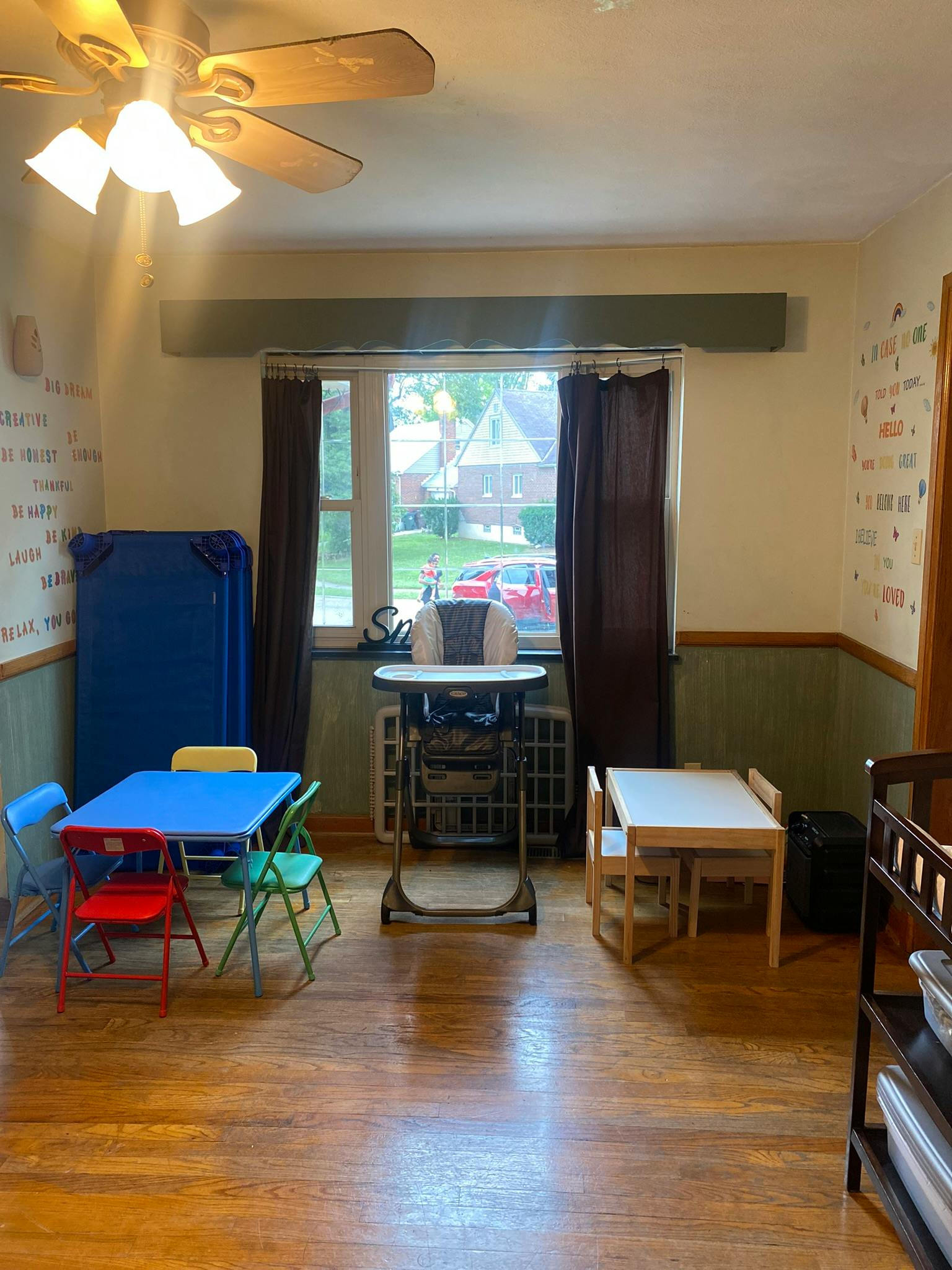 Room with small tables and chairs, a high chair, and a window