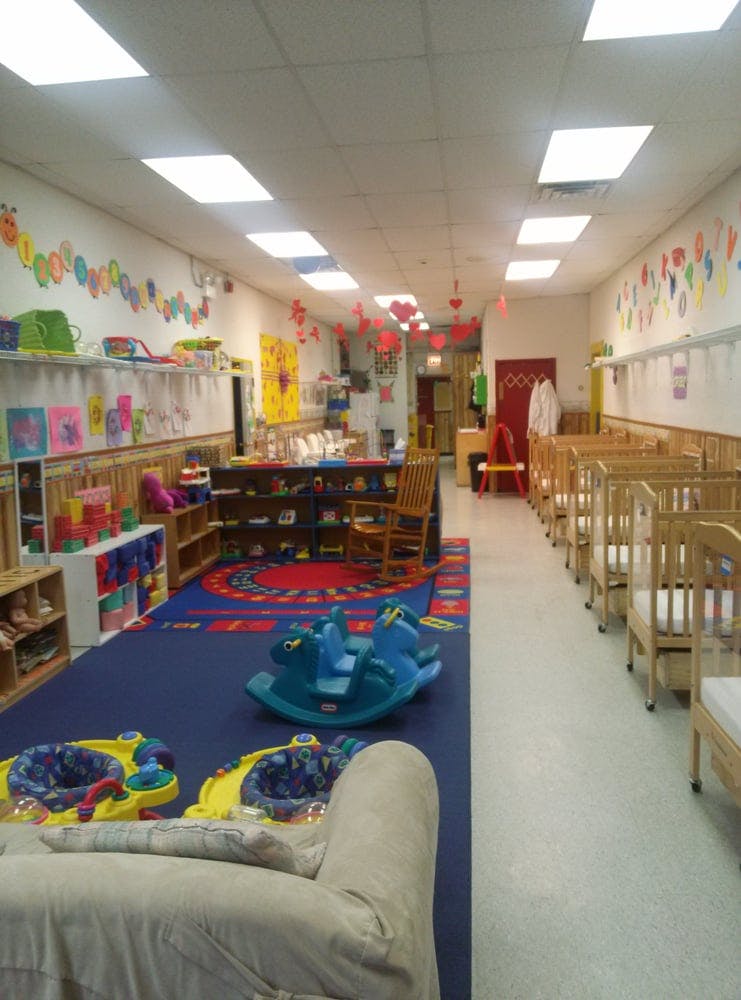 Daycare room with cribs, play area, and toys