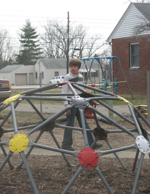 Child standing inside a geodesic dome climber
