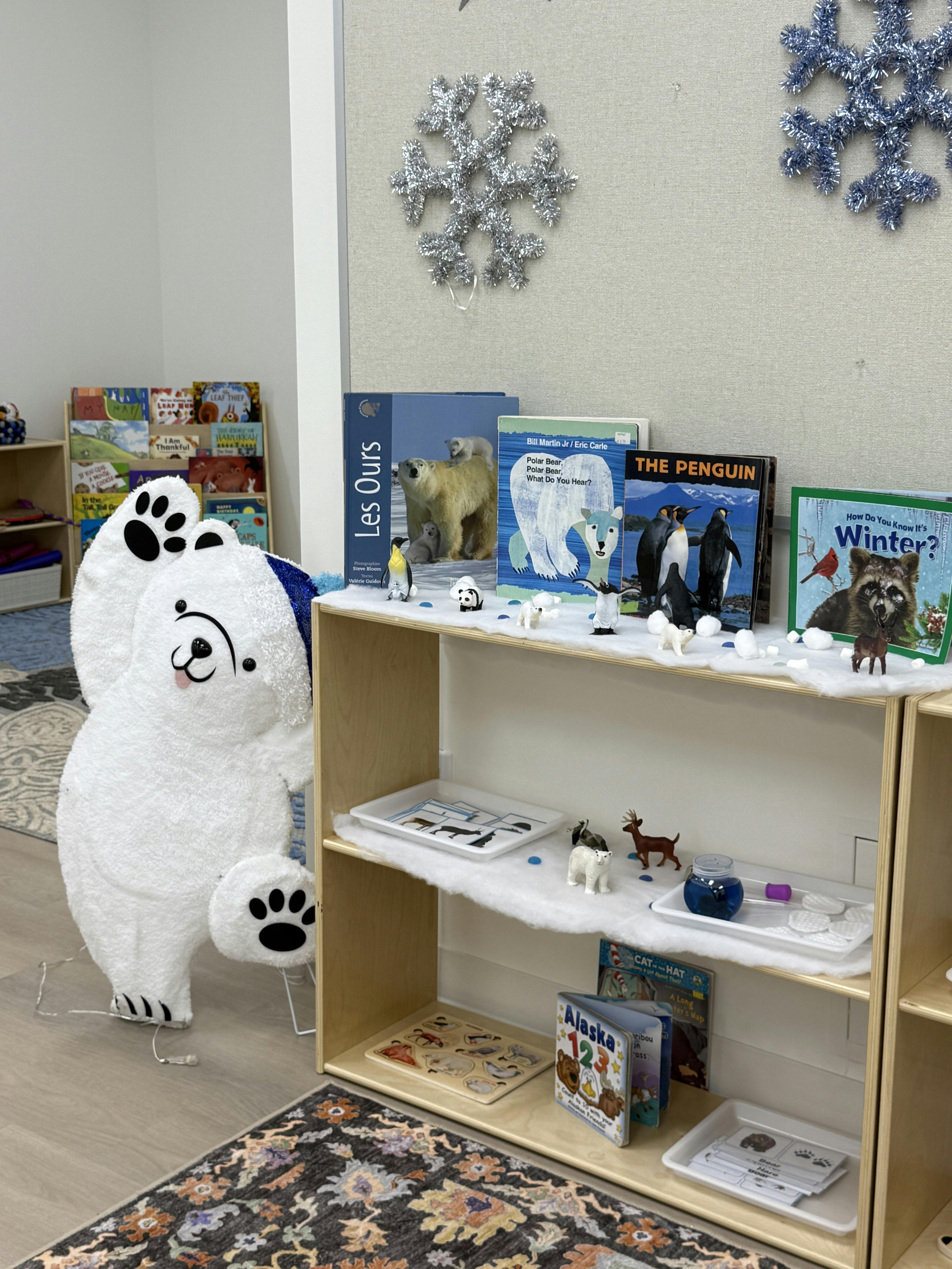 Classroom shelf with books and figurines related to winter animals