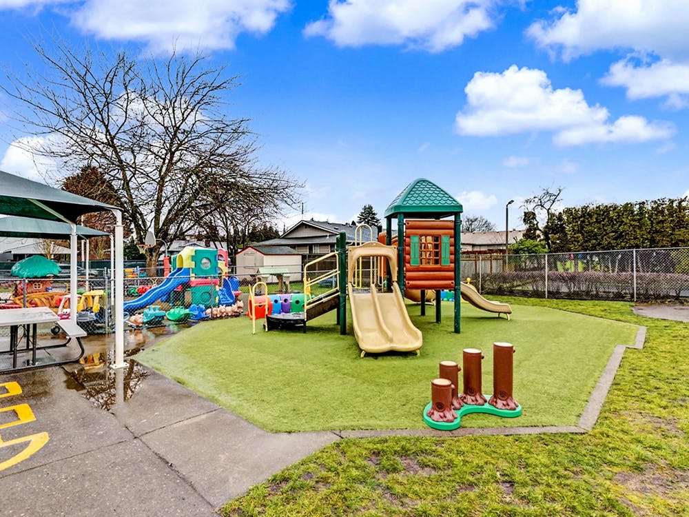 Children's playground with slides, climbing structures, and artificial turf