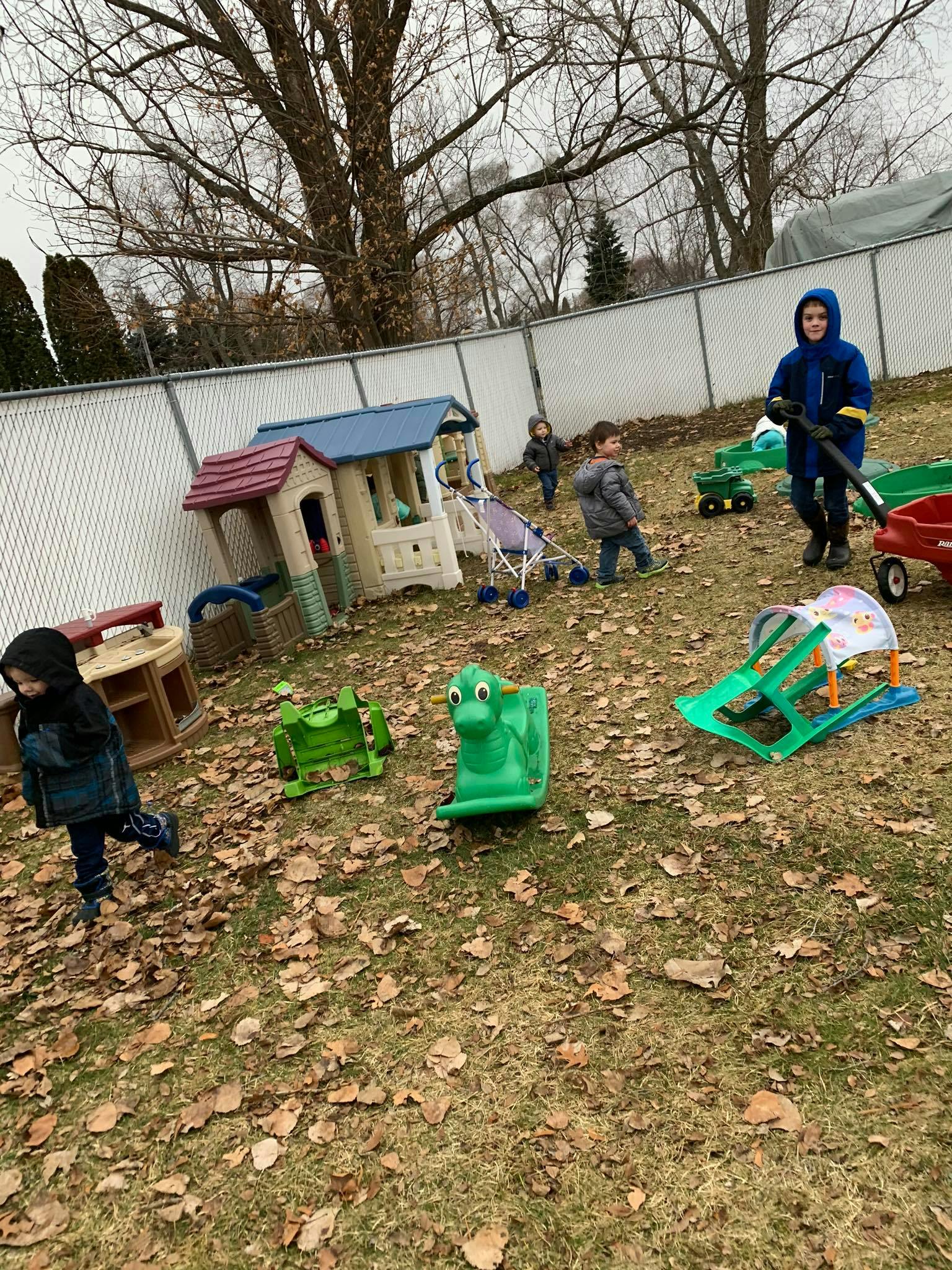 Children playing outdoors with various toys and playhouses