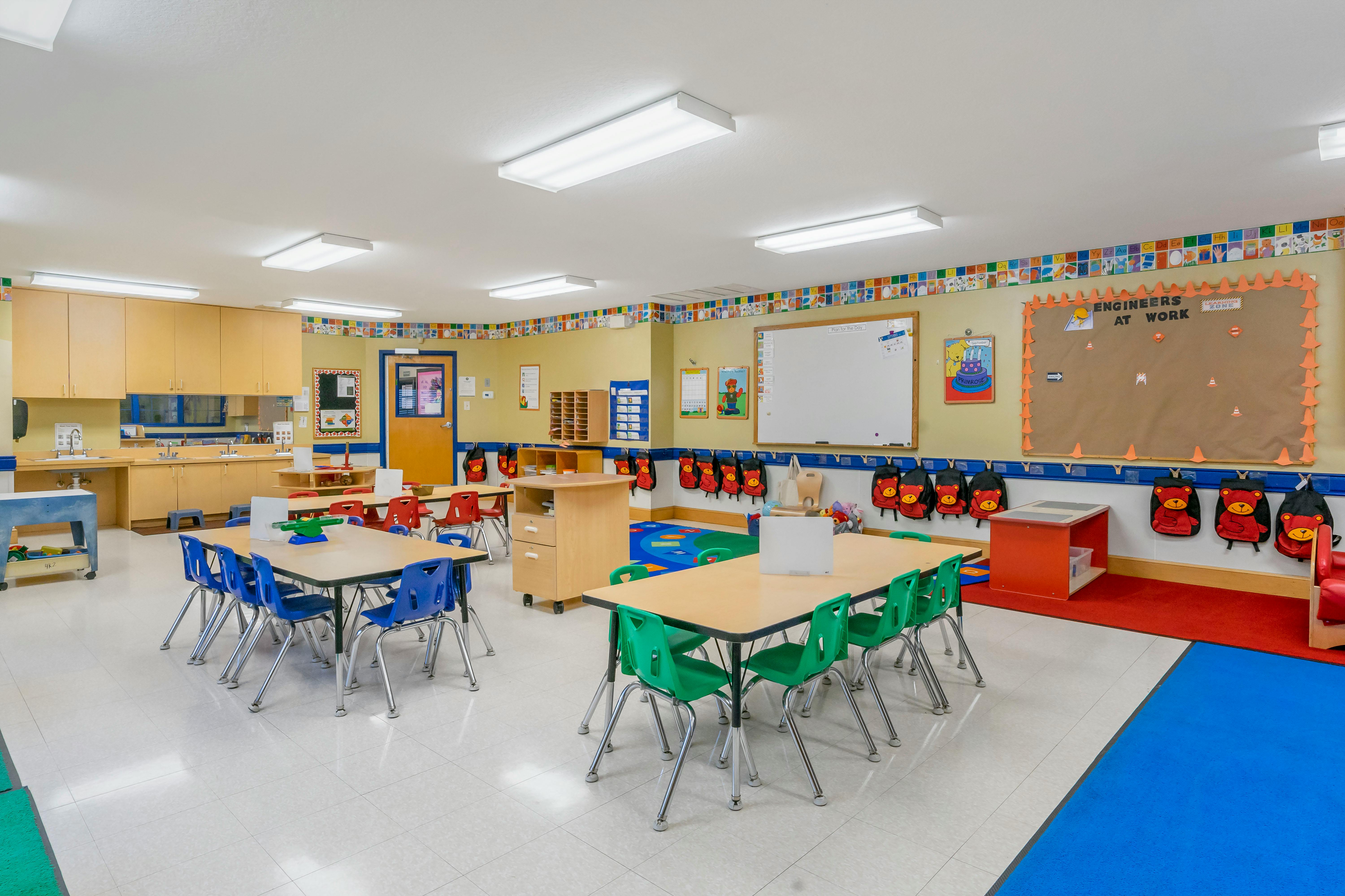 Empty colorful children's classroom with tables and chairs