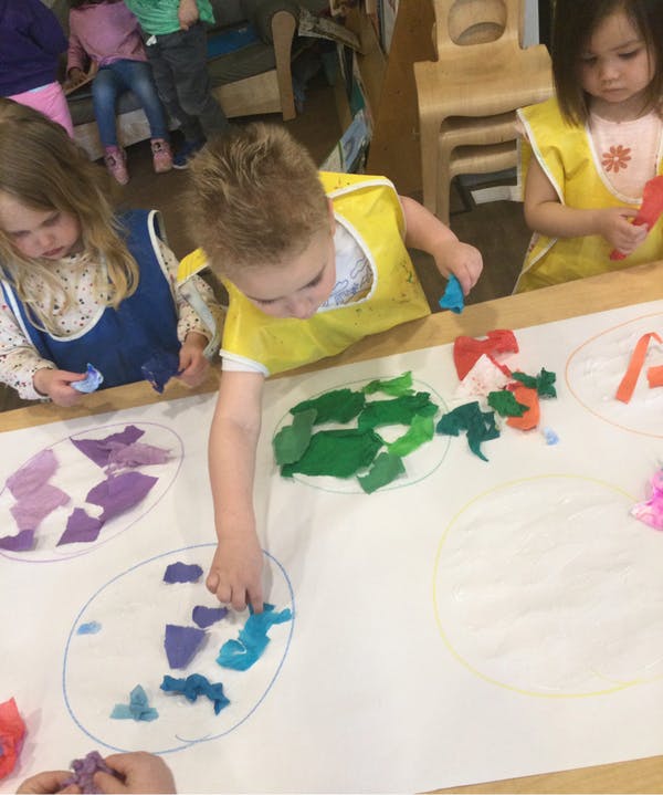 Children doing an art activity with colorful paper pieces