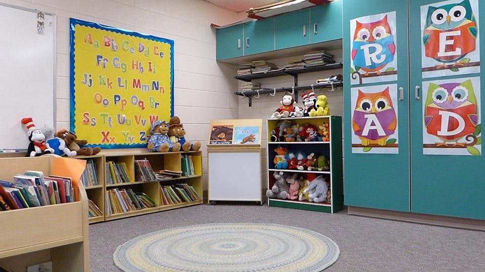 Classroom with alphabet chart, bookshelves, and owl decorations