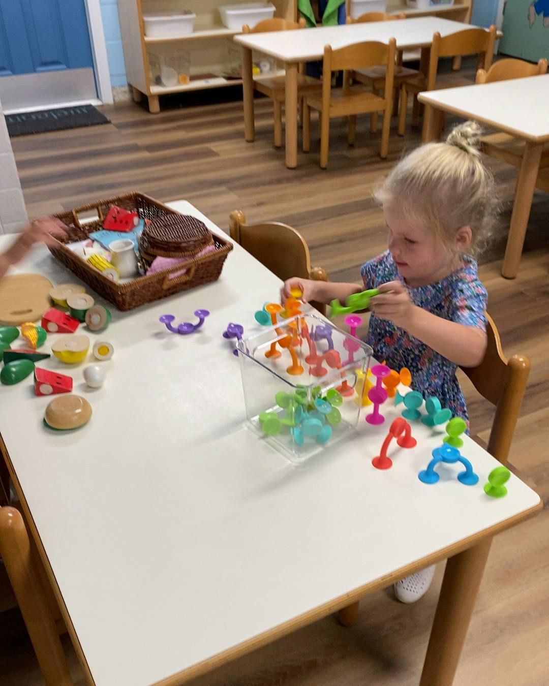 Child playing with colorful building toys at a table
