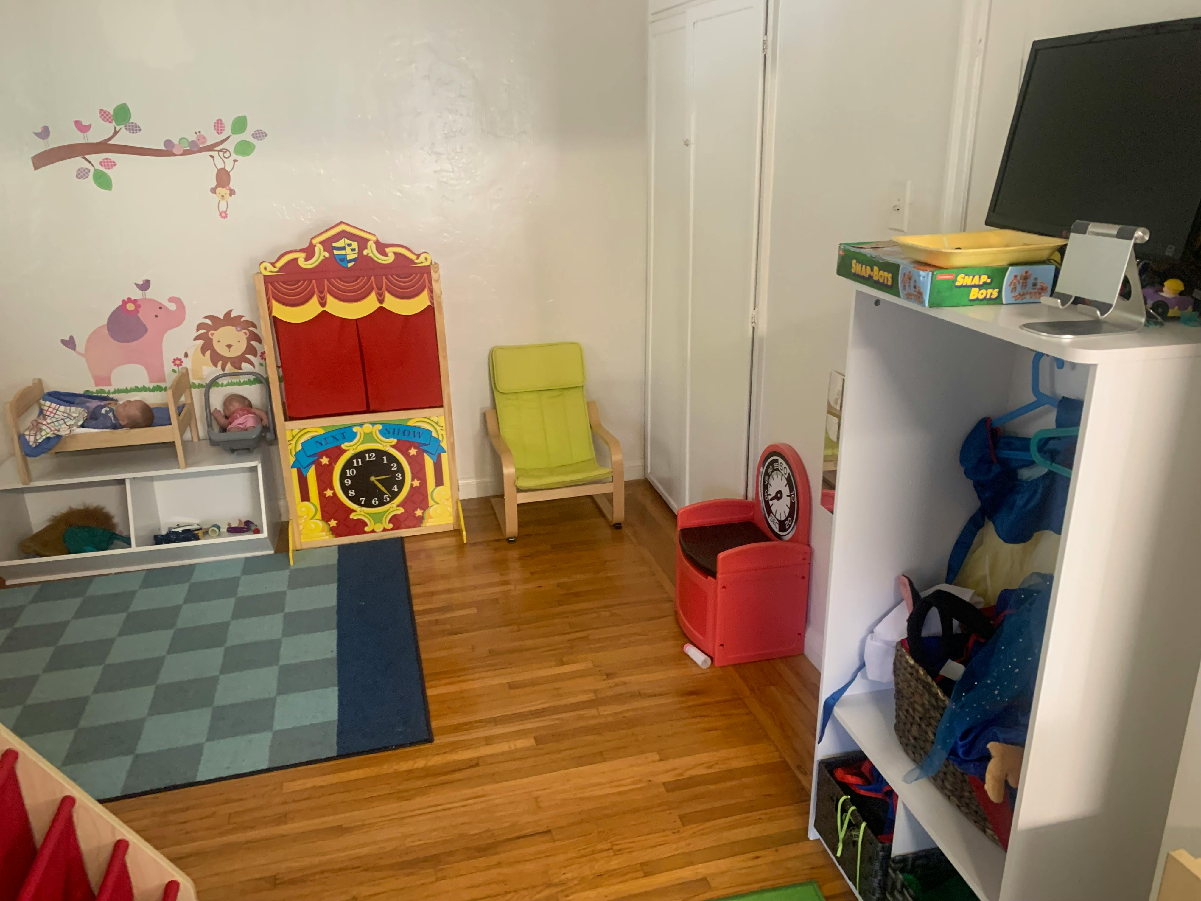 Playroom with a puppet theater, chairs, and storage shelves