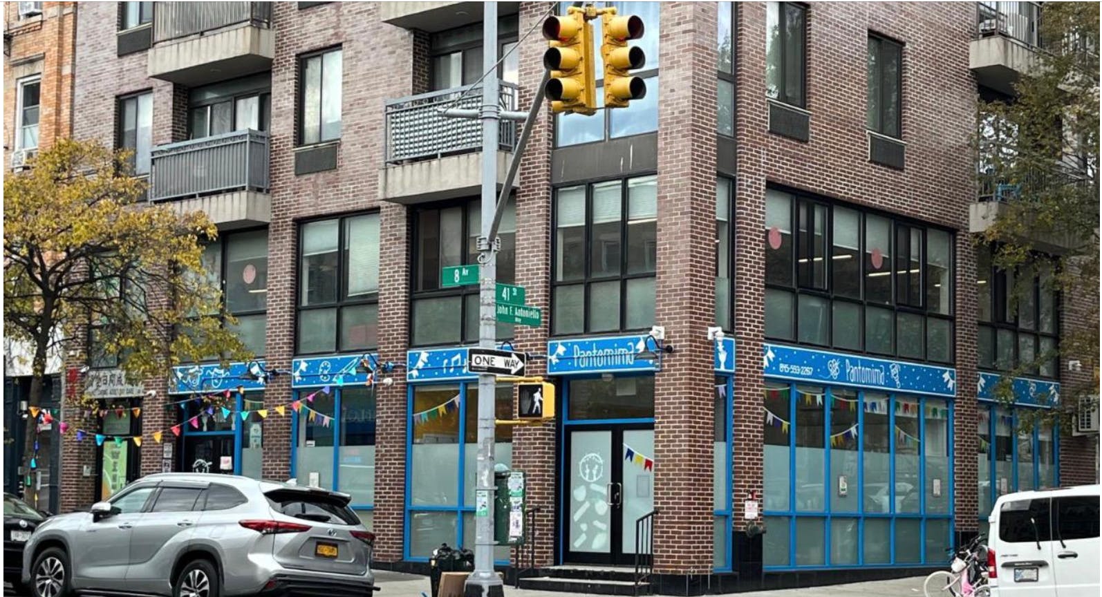 Brick building with blue storefronts for Pantomima and a traffic light on a corner