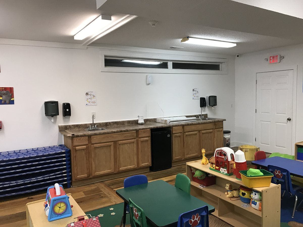 Classroom with sink, cabinets, and small tables with chairs