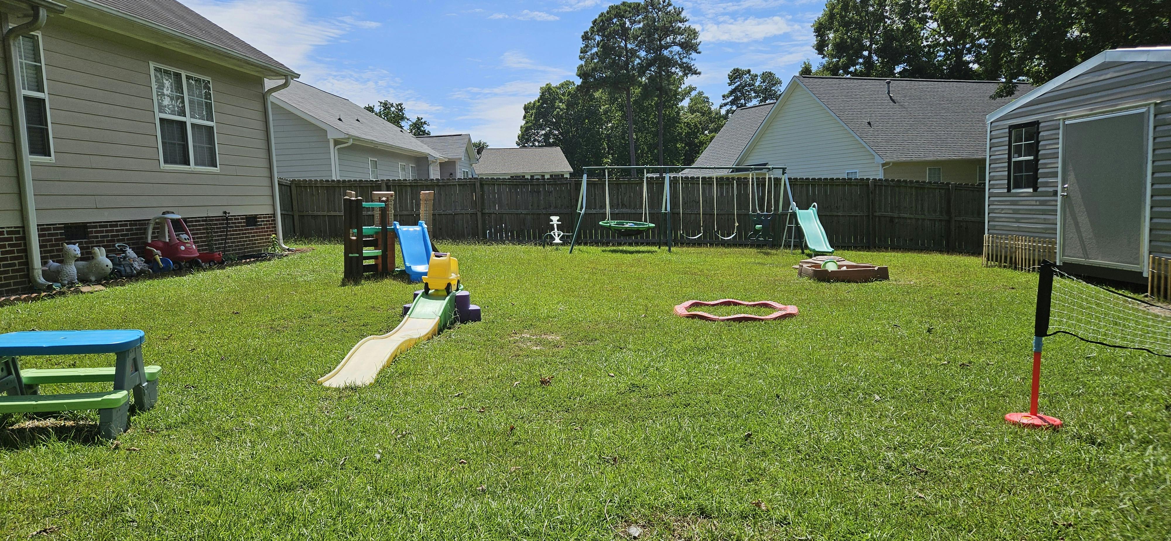 Backyard with playground equipment, slides, and a swing set