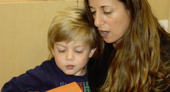 Adult and child looking at an orange object