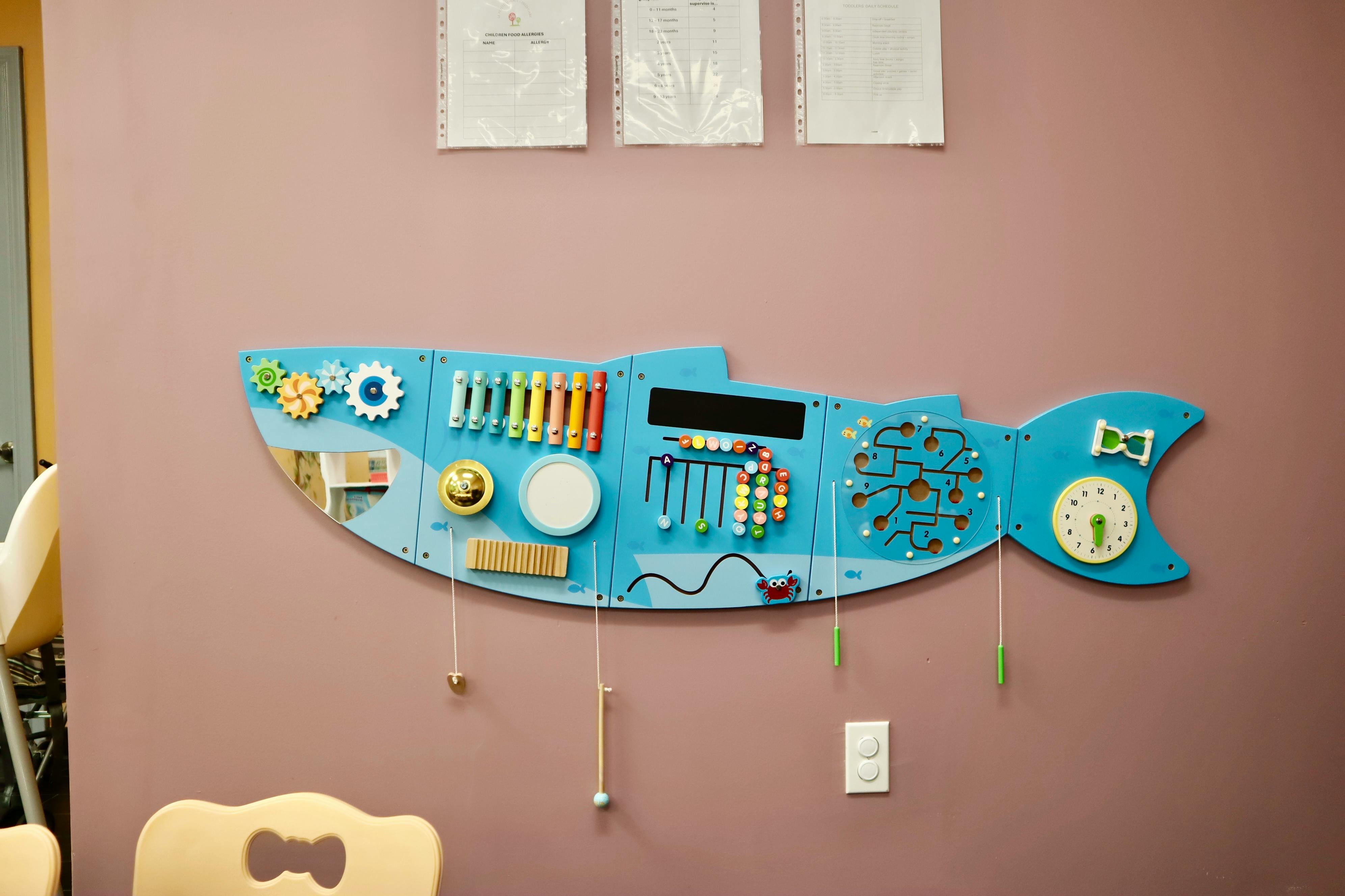Blue fish-shaped busy board with various activities on-board activities