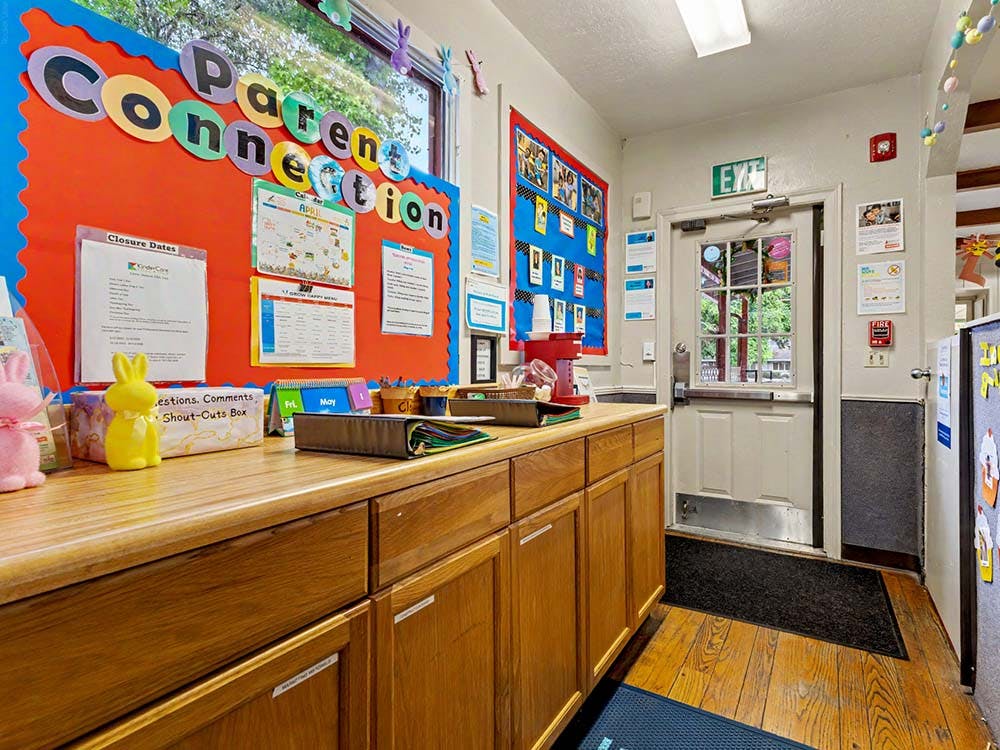 Bulletin board with "Parent Connection" title above wooden cabinets and an exit door