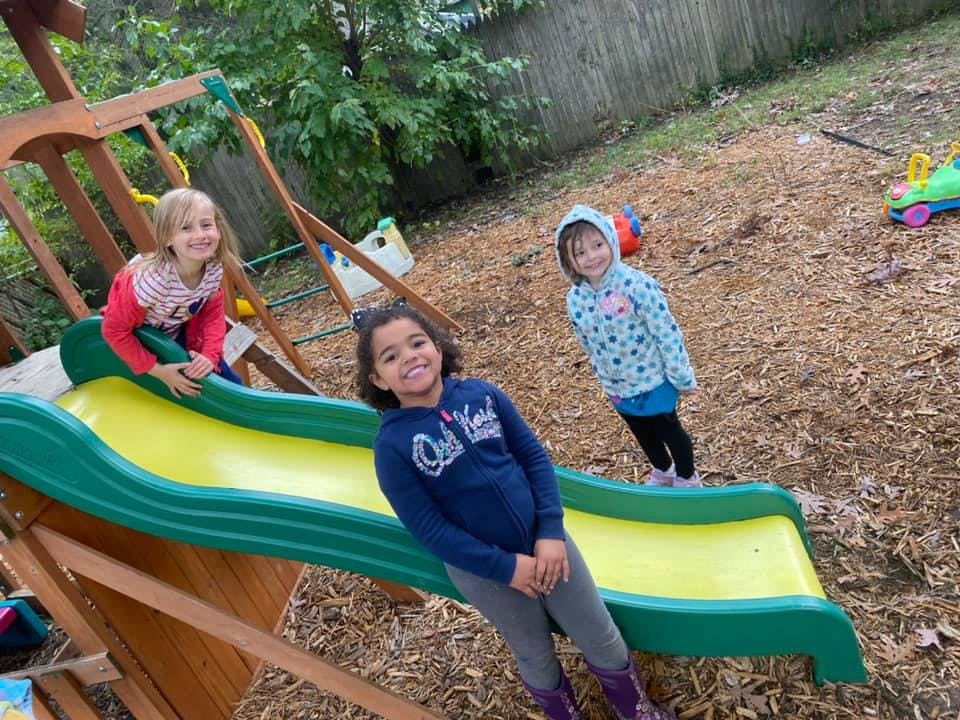 Three children on and around a playground slide