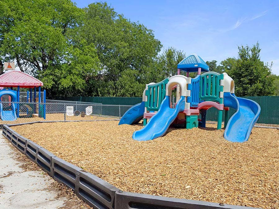 Playground with two slide structures on a wood chip surface