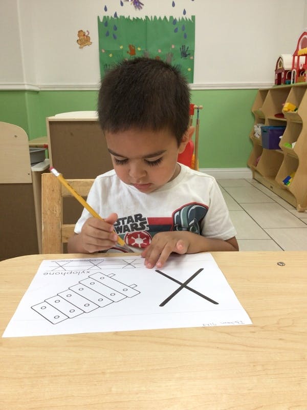 Child drawing on paper with a pencil