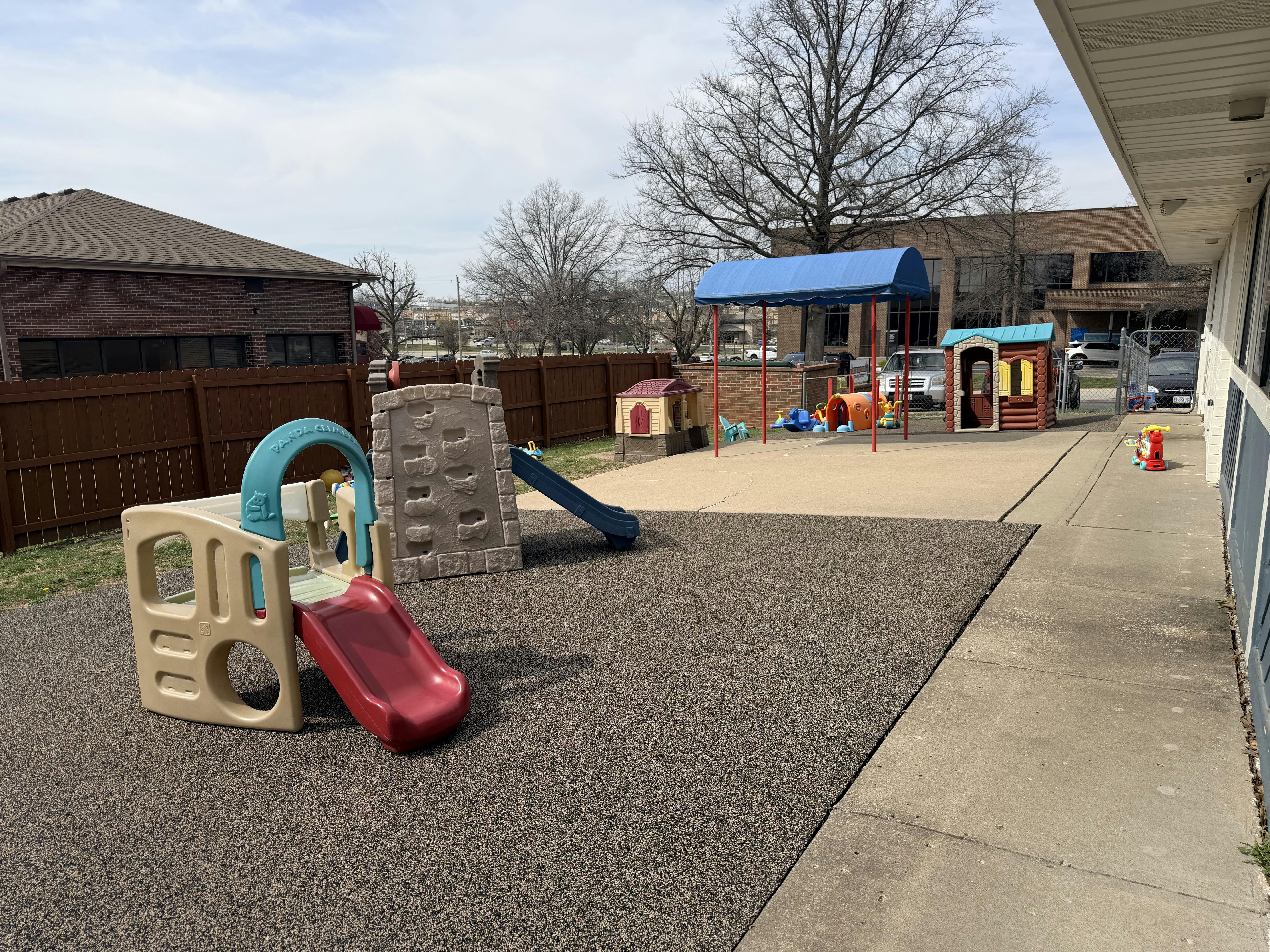 Outdoor playground with multiple slides, playhouses, and a climbing wall
