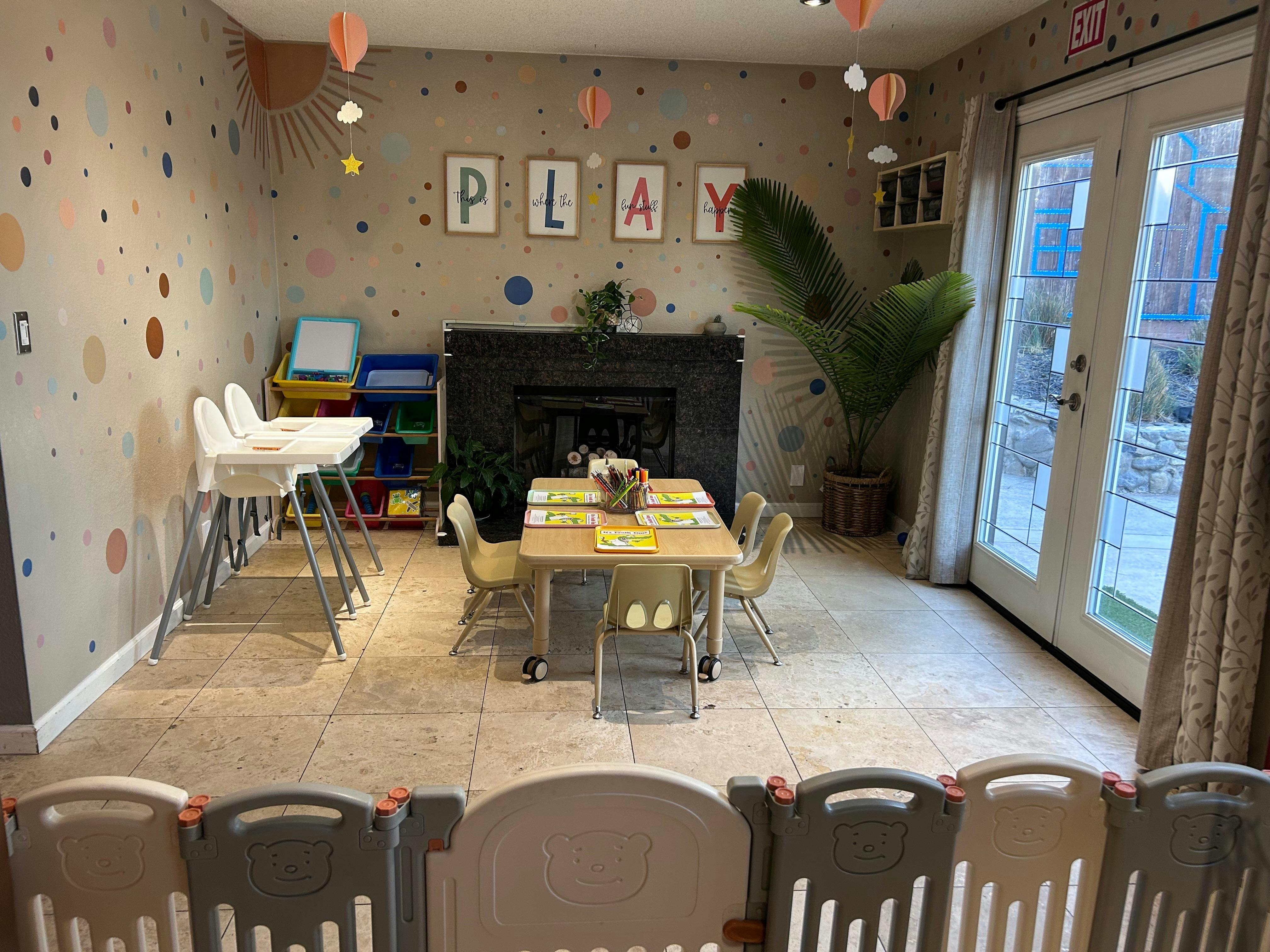 Child-friendly room with small table and chairs, high chairs, and a playpen