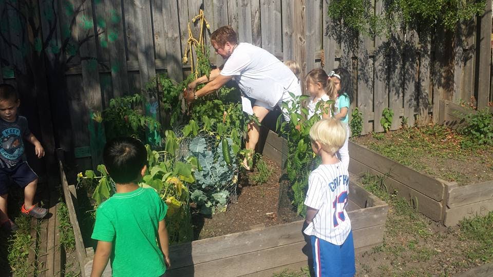 Person and children tending to plants in a garden